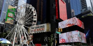 Una camioneta de la policía de la ciudad de Nueva York y un taxi cerca de la rueda de Times Square de 110 pies (33,5 metros) de altura, una noria que se construyó en Times Square en Nueva York EEUU. EFE
