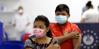Dos niños sosteniendo un algodón en el lugar donde recibieron su primera dosis de la vacuna contra la covid-19. EFE