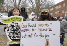 dos personas con pancartas durante una manifestación en Albany, Nueva York. EFE