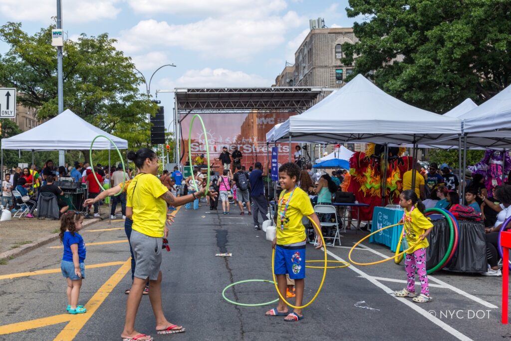 Niños juegan en el área de descanso de Poe Park durante el programa Calles de Verano 2024 en el Bronx. Crédito: NYC DOT
