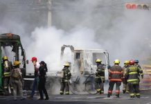 Integrantes del Cuerpo de Bomberos de Guadalajara intentan apagar un vehículo incendiado este domingo, en Guadalajara (México). EFE