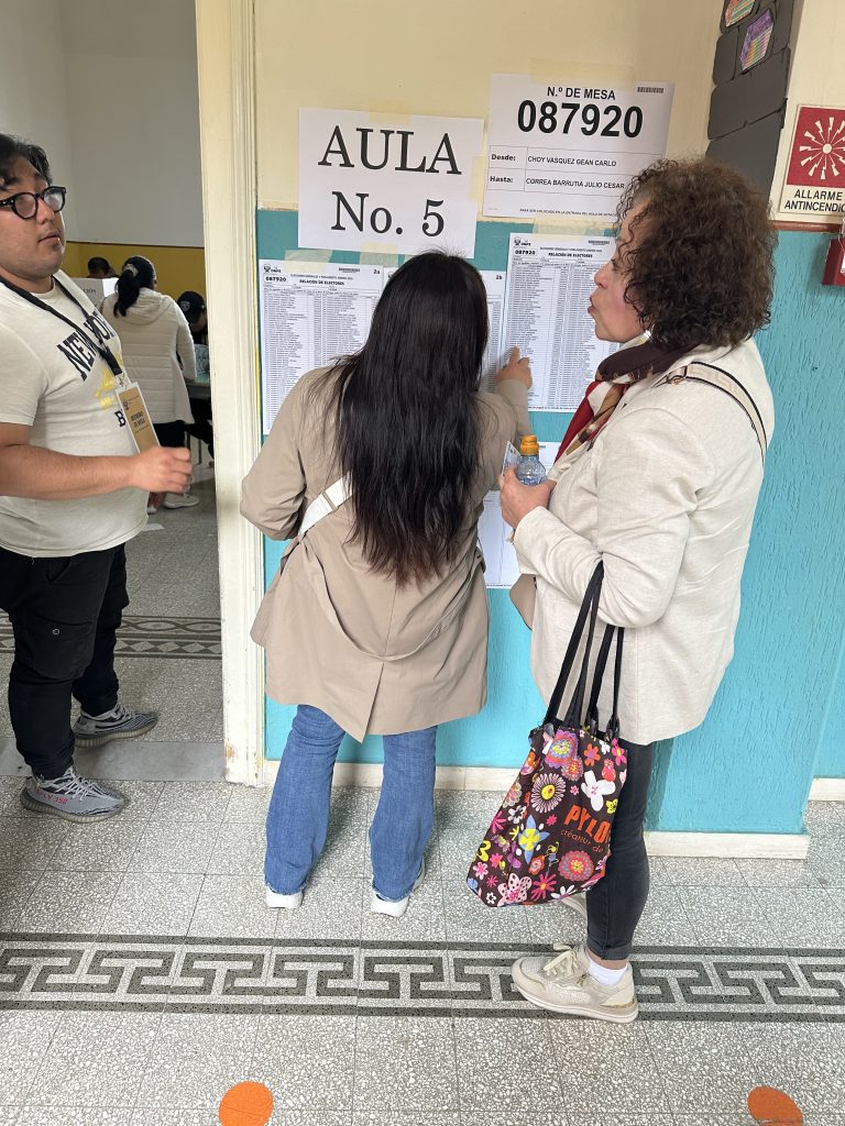 Dos peruanas buscando sus nombres en la lista de votantes adyacente a las mesas de sufragio en el Instituto Santa Caterina da Santa Rosa, uno de los dos centros de sufragio instalados por el Consulado del Perú en Roma para las elecciones generales del 12 de abril del 2026. Foto: Carmen Valdivieso Hulbert